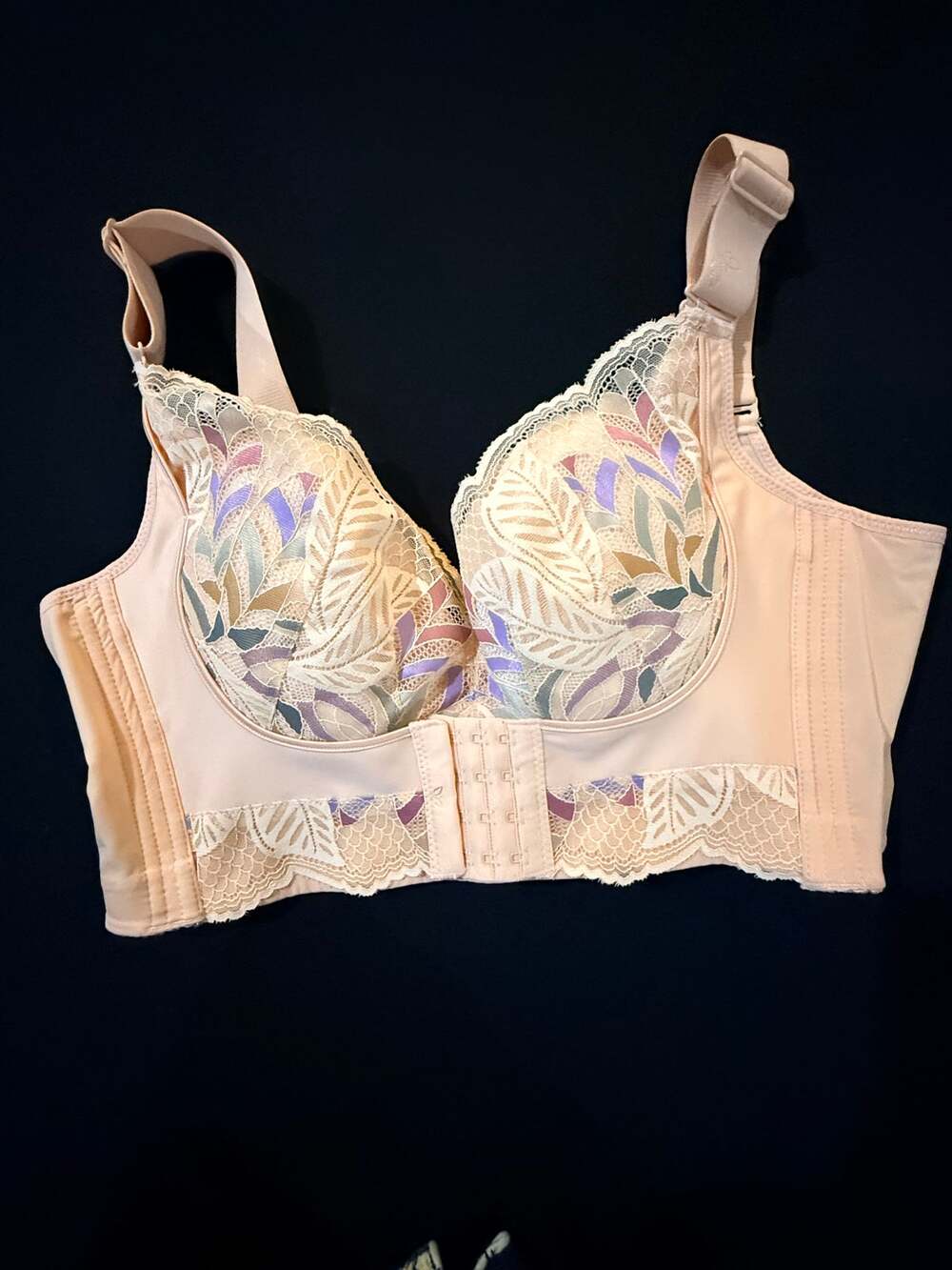 Women's peach/nude floral lace bra purple, sage green, and pink leaf designs.